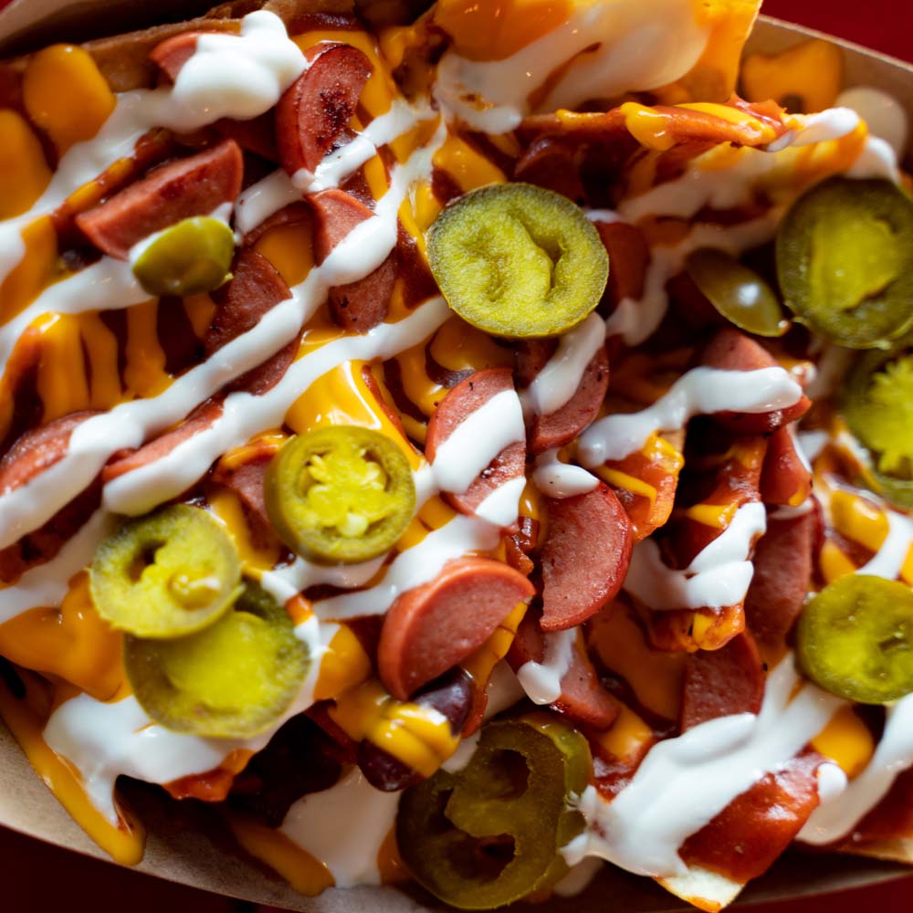 Lucky Louie’s Nacho Average Wiener features Smith’s diced Wieners, Chili, Cheese Sauce, Jalapenos, Sour Cream, on a Mountain of Chips.